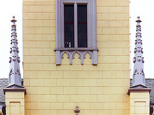 Die neugotischen Fialtürmchen aus Betonwerkstein einer Rathausfassade.